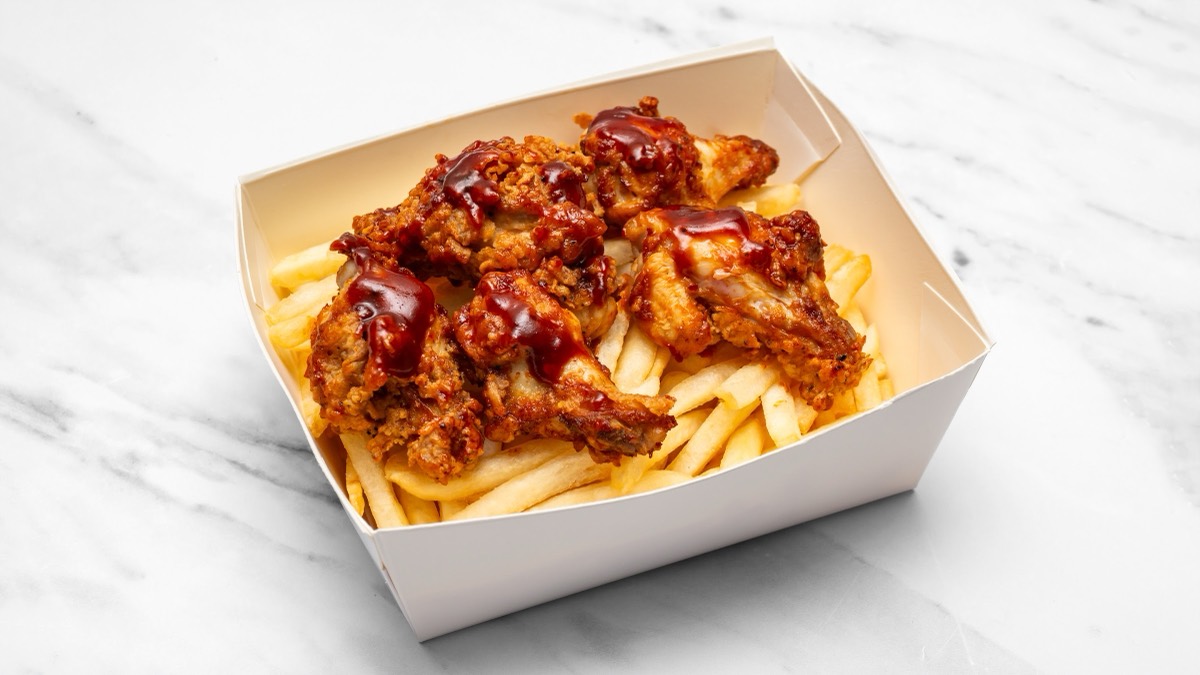 BBQ chilli wings glazed and piled over chips in a takeaway box